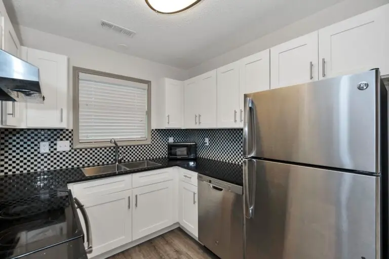 silver top mount refrigerator beside white wooden kitchen cabinet