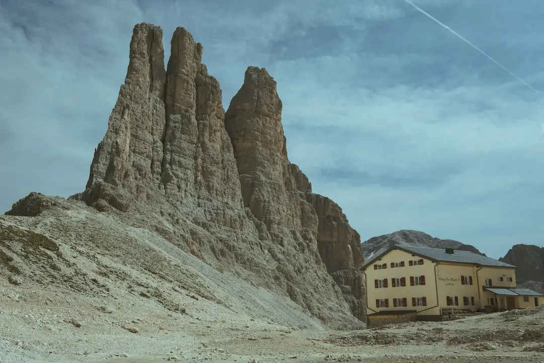 a house in the middle of a desert with a mountain in the background