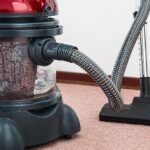 Black and Red Canister Vacuum Cleaner on Floor