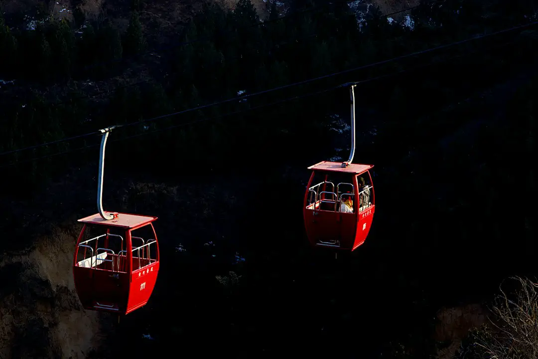 a couple of red gondolas hanging from a wire